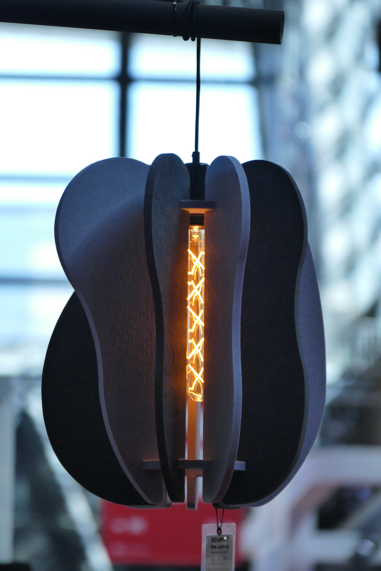 Szara geometryczna lampa akustyczna dźwiękochłonna z ozdobną żarówką prezentowana na targach Batimat 2022