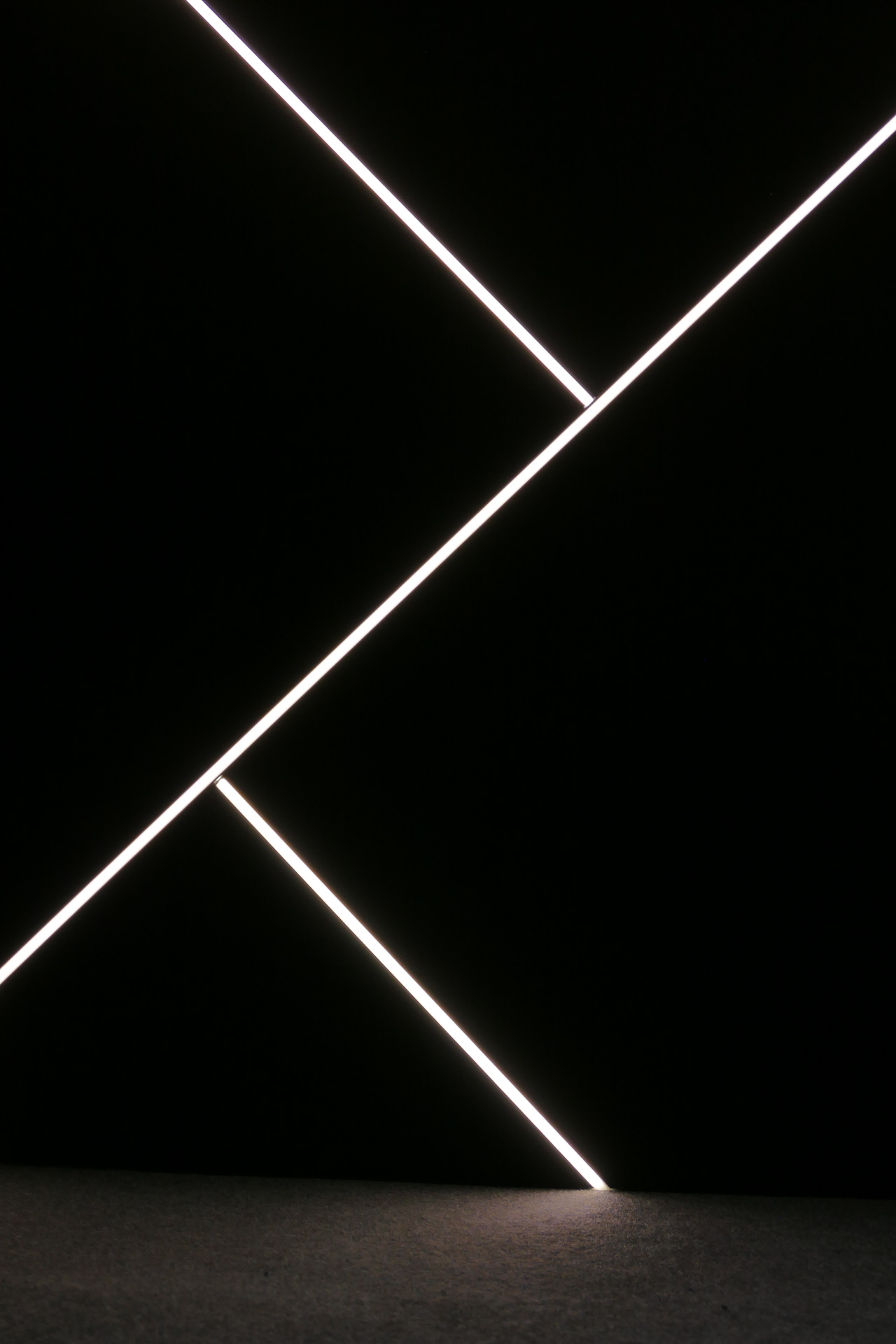 Czarna ściana z dekoracyjnym liniowym oświetleniem LED z paneli akustycznych EcoPET prezentowana na targach Batimat 2022